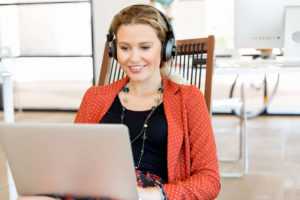 Woman typing on a laptop with headphones on