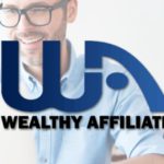 Man sitting at a table working on laptop with the Wealthy affiliate logo